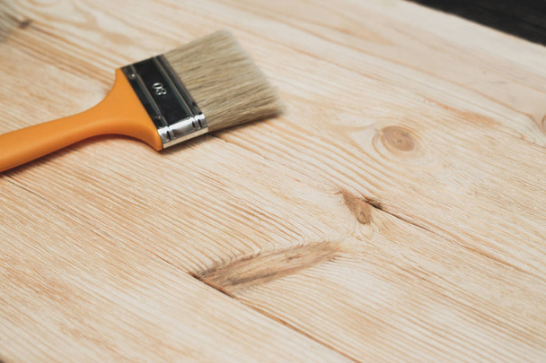 Brushed wooden surface with a brush lying on the background. The concept of decorating repairs - Fotó, kép