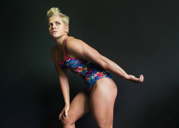 photo athletic girl posing in a swimsuit gray background - Photo, Image