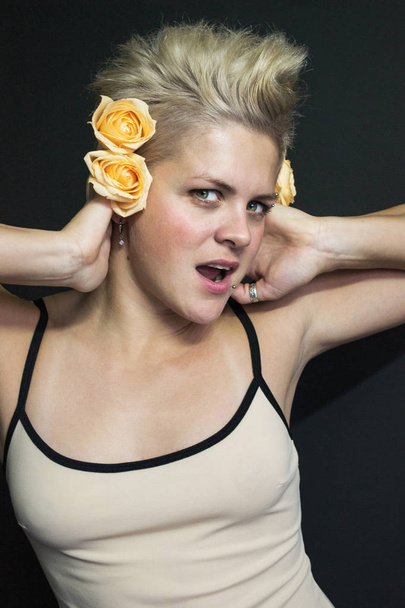 Fotoporträt eines blonden kurzhaarigen Mädchens mit Rosen im Haar - Foto, Bild