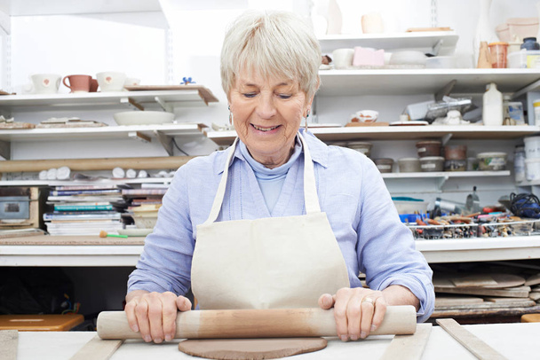 Senior Woman Rolling Out Clay In Pottery Studio - Fotoğraf, Görsel