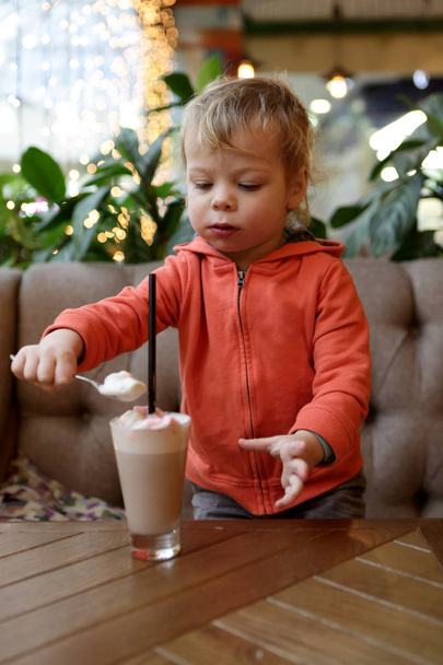 Child eating foam of cocoa - Valokuva, kuva