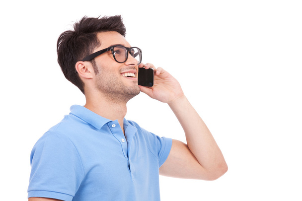 νεαρός άνδρας στο τηλέφωνο κοιτώντας μακριά - Φωτογραφία, εικόνα