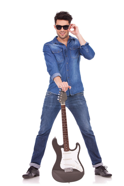 young man with guitar between legs - Φωτογραφία, εικόνα