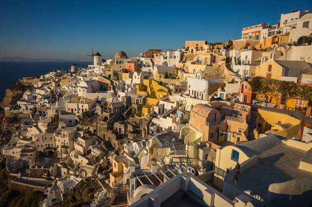 White city on  slope of  hill at sunset, Oia, Santorini - Foto, afbeelding