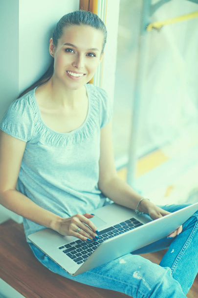 Young beautiful woman using a laptop computer at home - Fotó, kép