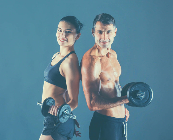 Athletic man and woman with a dumbells - Photo, Image