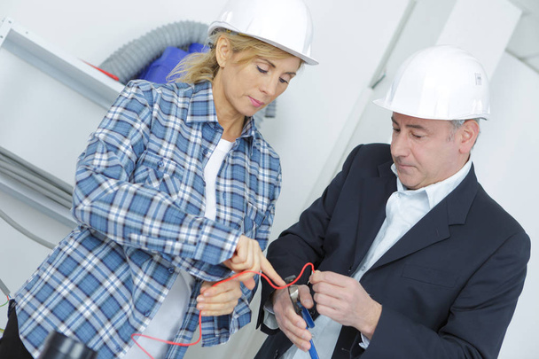 biznesmen i kobieta pracownika w twardym kapelusze w budowie - Zdjęcie, obraz