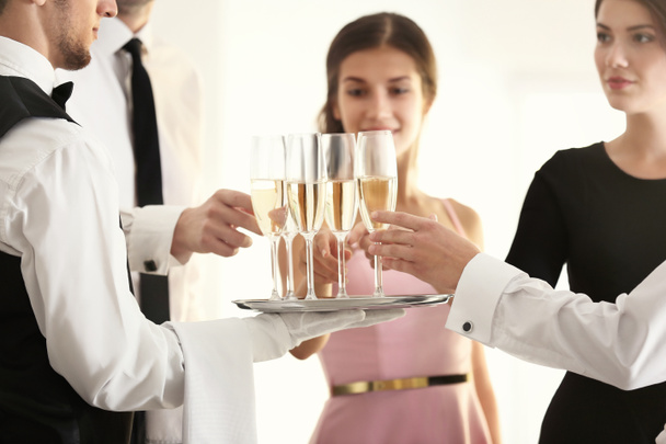 ビュッフェ パーティーをケータリングの中にシャンパンを提供制服を着たウェイター - 写真・画像