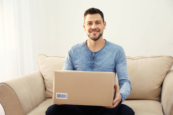 Handsome young man with parcel - Foto, imagen