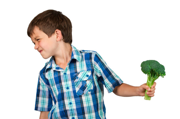 Jeune garçon tournant la tête loin d'une grappe de brocoli
 - Photo, image