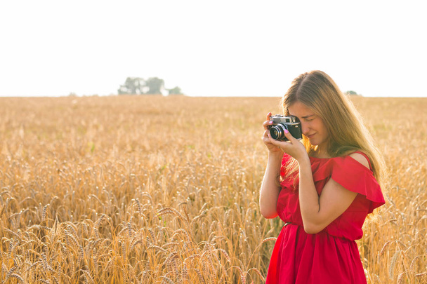 γυναίκα φωτογράφος στο πεδίο με μια φωτογραφική μηχανή φωτογραφίζετε - Φωτογραφία, εικόνα