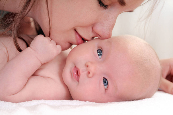 retrato de bebê pequeno bonito e sua mãe beijando-a
 - Foto, Imagem