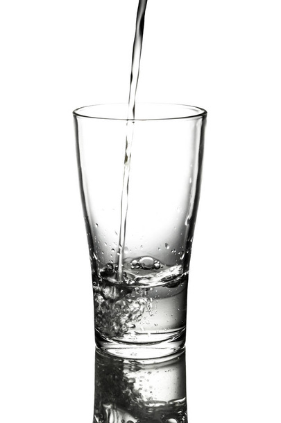 πόσιμο νερό ρίχνει σε ποτήρι. - Φωτογραφία, εικόνα