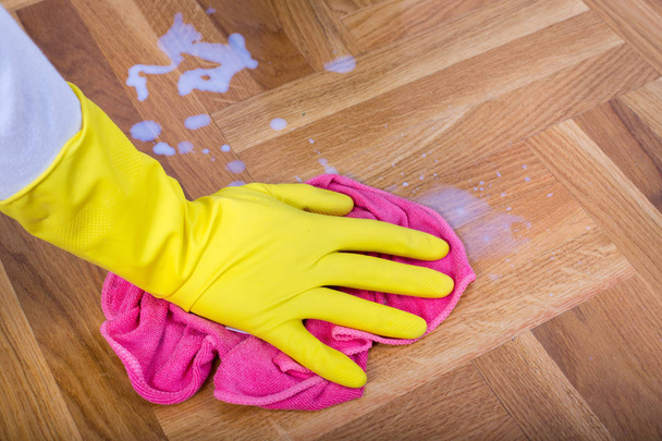 Mano con guantes limpiando el suelo
 - Foto, imagen