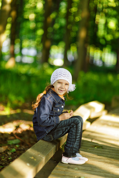 dziewczynka w kolorze denim siedział na poręczy drewnianych - Zdjęcie, obraz