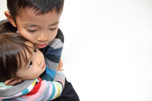 Japanese brother and sister hugging each other (7 years old boy and 2 years old girl) - Photo, Image