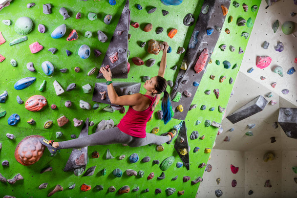 Joven mujer bouldering en escalada gimnasio
 - Foto, Imagen