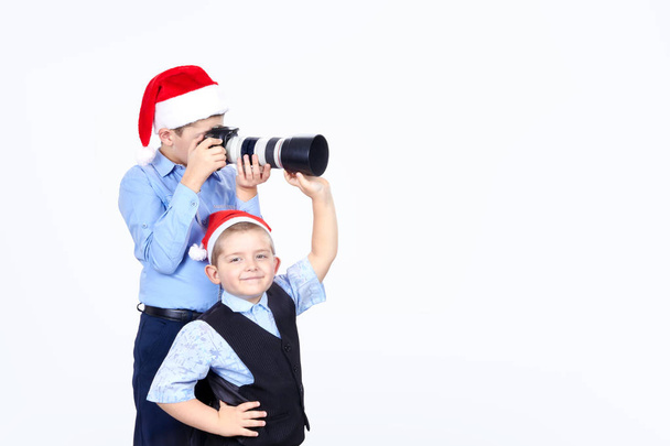 Sobre fondo blanco aislado chicos están fotografiando en gorras de Santa Claus
 - Foto, imagen