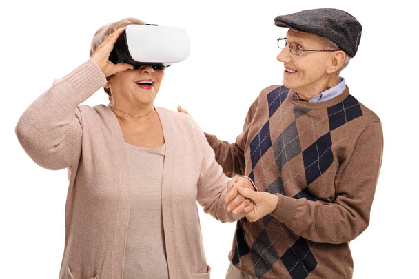 woman using a VR headset with a man holding her hand - 写真・画像