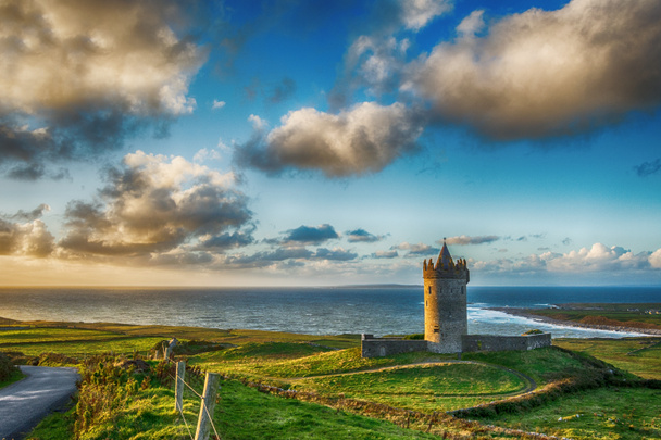 ドゥーリン クレア州、アイルランドの野生の大西洋方法の壮大な夕日は。古いアイルランドの城と沿岸のビーチの景色の美しい景観. - 写真・画像