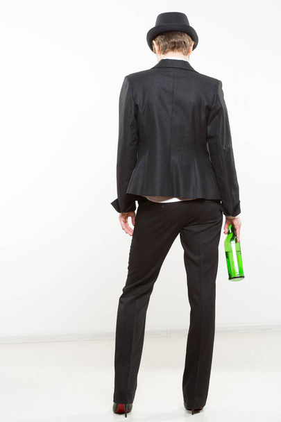 elegant woman in a business suit, holding bottle of alcohol. - Foto, Imagem