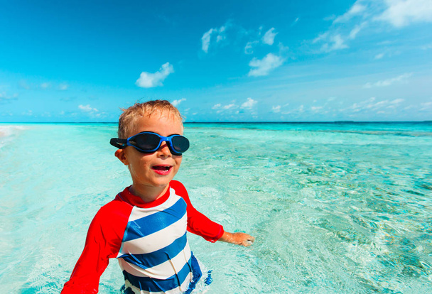 glücklicher kleiner Junge schwimmt am tropischen Strand - Foto, Bild