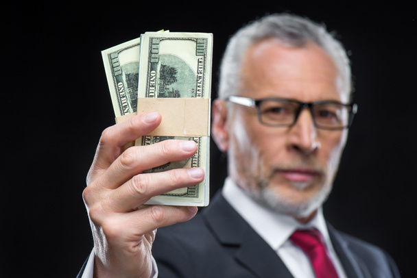 Businessman holding dollar banknotes - Фото, изображение