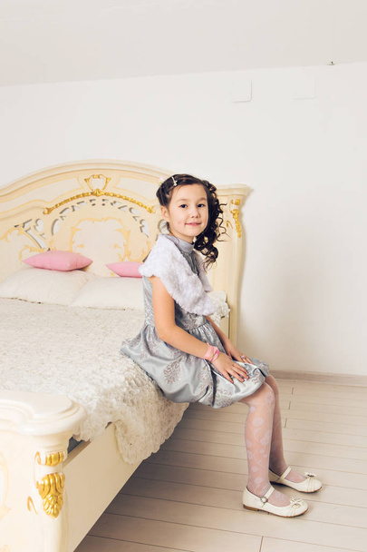 Portrait of adorable asian girl sitting on the bed - Foto, Imagem