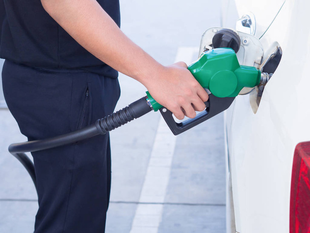 man handle fuel nozzle to refuel.  in gas station. - Photo, image