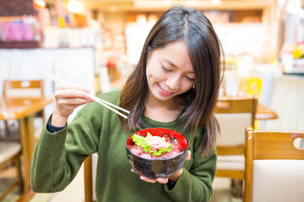 Mulher tendo sashimi don no restaurante
  - Foto, Imagem