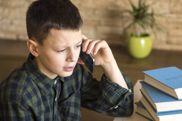 Young Boy Talking on Cell Phone at Home. Mobile Phone Talk Concept. - 写真・画像
