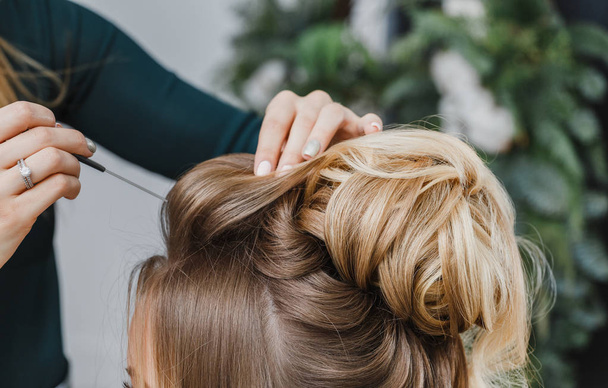 Hände einer Frau beim Kämmen der Haare ihres Kunden im Schönheitssalon - Foto, Bild