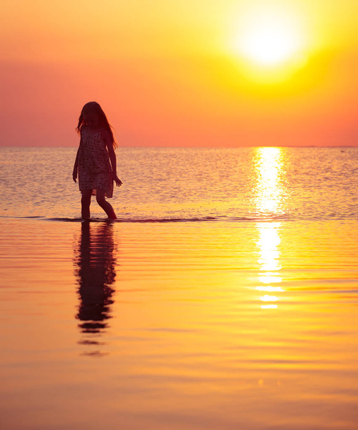 child girl walking at the sunset sea  - Foto, immagini