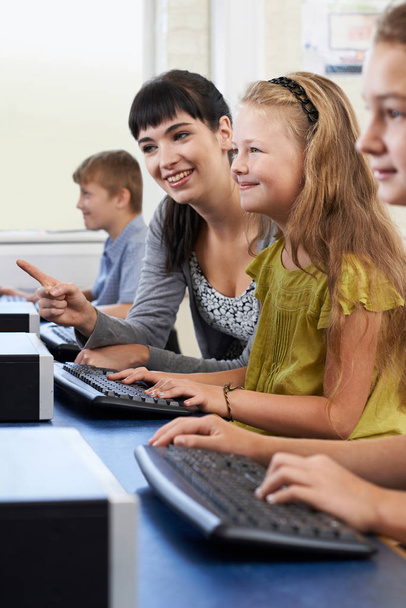 vrouwelijke elementaire leerling van computer klas met leraar - Foto, afbeelding