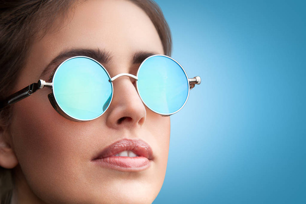 Konterfei einer jungen schönen Frau mit runder Sonnenbrille - Foto, Bild