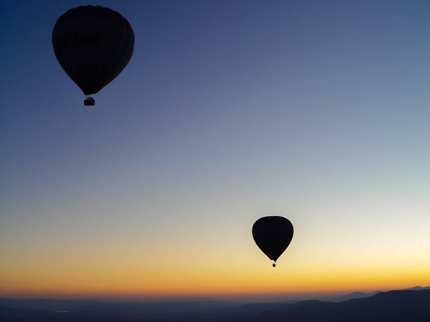 Silhouette of hot air balloons flying over the Cappadocia valley - Photo, Image