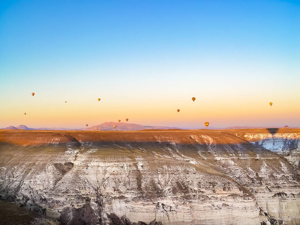 Bunte Heißluftballons fliegen in Kappadokien über das Tal - Foto, Bild