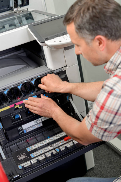 man fixing photocopier and middle-aged - Φωτογραφία, εικόνα