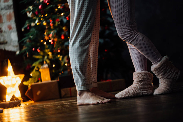 Legs of couple on Christmas tree background - Photo, image