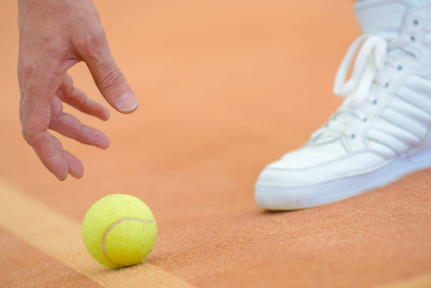 picking up tennis ball - Фото, изображение