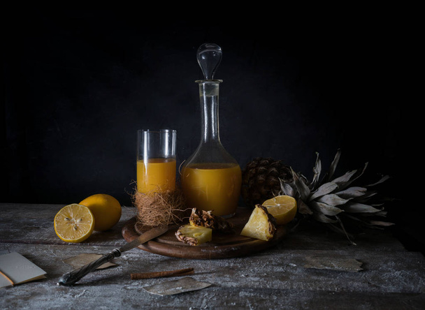 still life. pineapple, lemon, tropical juice, old silver knife on a wooden table - Foto, Imagem
