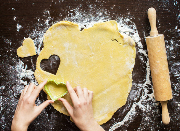 Womans hands made from the dough heart. Cooking, flour, love - Фото, изображение