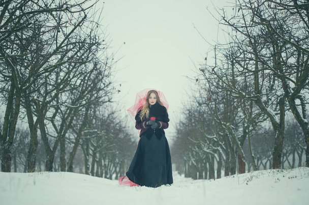 Dziewczyna w czerwonym welonem na śniegu w zimie - Zdjęcie, obraz