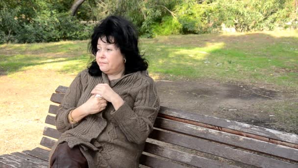 Mulher com vício tomando pílulas de dor no banco de madeira
 - Filmagem, Vídeo