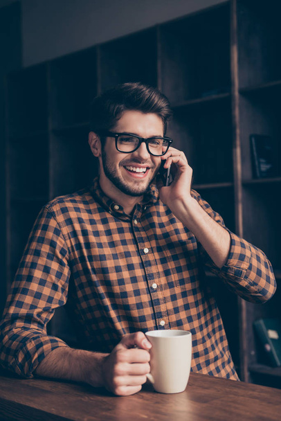 Happy smiling man drinking tea and talking on mobile phone in of - Фото, зображення