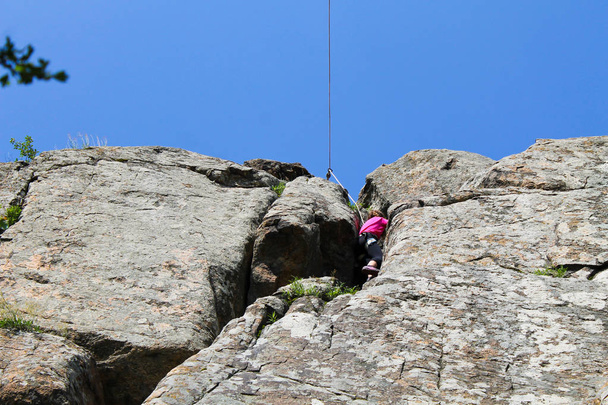 Dziewczyna alpinistka wspina się na skale - Zdjęcie, obraz