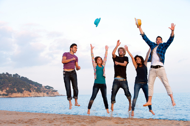Группа молодых друзей, прыгающих на пляже
. - Фото, изображение
