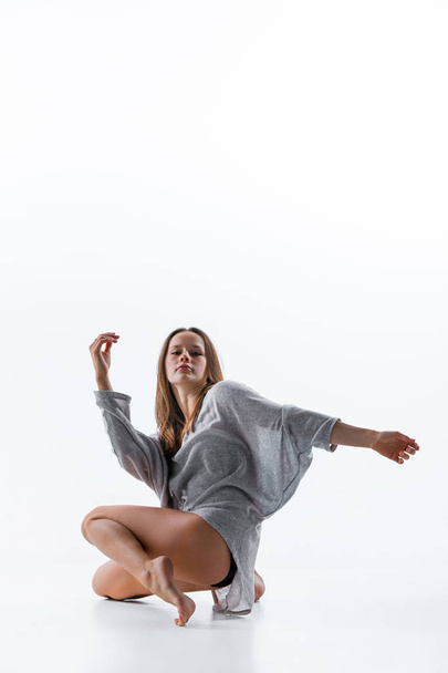 Young beautiful dancer in beige dress dancing on white background - Foto, Bild