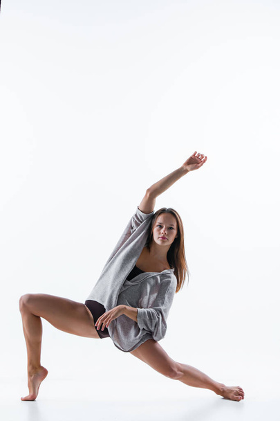 Young beautiful dancer in beige dress dancing on white background - Foto, Imagem