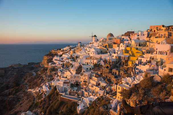 White city on  slope of  hill at sunset, Oia, Santorini - Foto, afbeelding